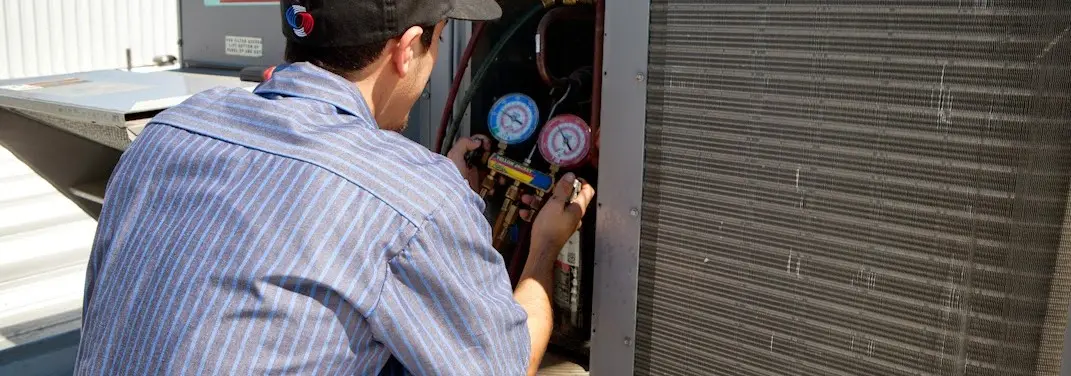 HVAC technician servicing a condenser unit in Doney Park